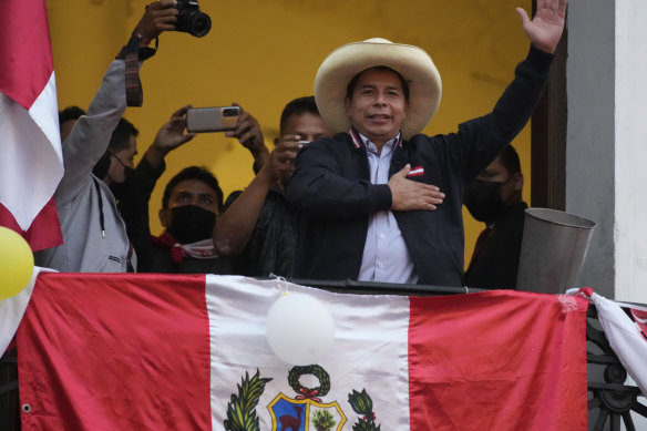 Presidential candidate Pedro Castillo waves to supporters celebrating partial election results that show him leading over Keiko Fujimori, at his campaign headquarters in Lima, Peru.