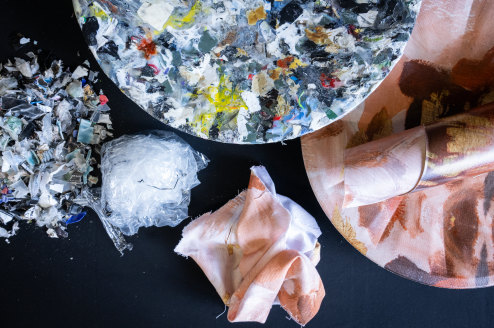 Stages of the process from shredded plastic (left), composite matrix bowl (multicoloured, top), laminated fabric and finished bowl (right).