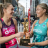 Adelaide Thunderbirds captain Hannah Petty and Melbourne Vixens counterpart Kate Moloney with the Super Netball trophy.