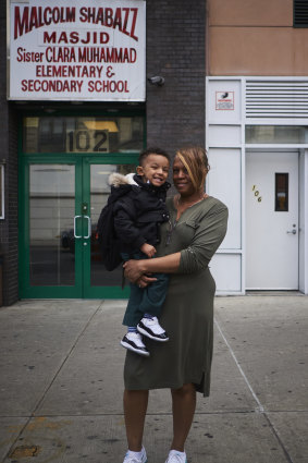 Donna Mosley with her grandson, who has not been vaccinated against measles, outside the Sister Clara Muhammad Elementary School and mosque in the Harlem area of New York.