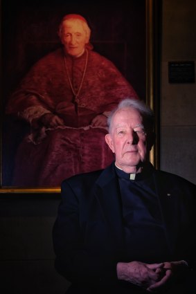 Father Bill Uren, rector of Melbourne University's Newman College, with the college's portrait of John Henry Newman in his cardinal's robes.