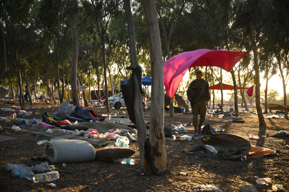 Israeli soldiers search for ID and belongings among the cars and tents at the Supernova Music Festival site on October 12.