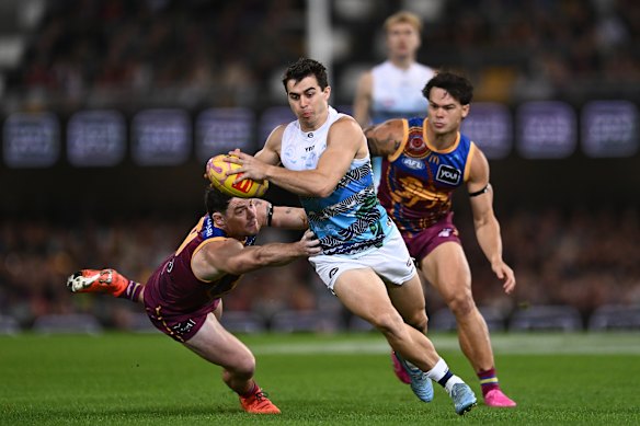 Oisin Mullin of the Cats gets past Lachie Neale and Cam Rayner of the Lions.