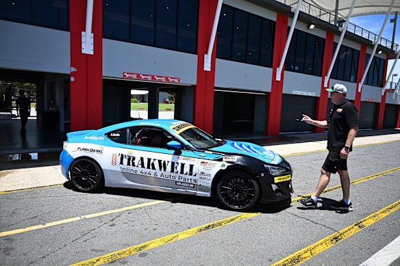 Craig Baills directs his 17-year-old son Angus as he reverses their race car.