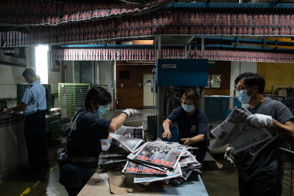 Employees arrange the Apple Daily newspaper on Tuesday. 