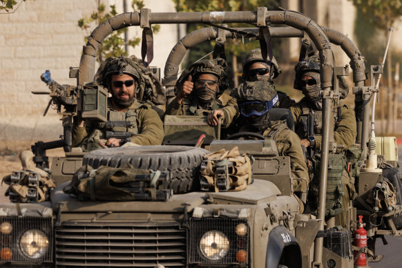 An Israeli soldier gives a thumbs-up gesture as Israeli troops move near the border with Gaza. 
