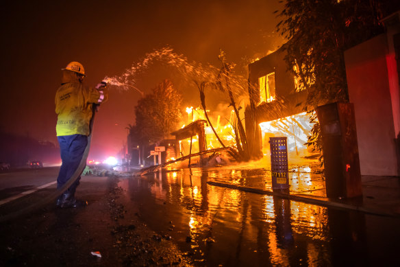  A firefighter battles the Palisades fire while it burns homes on the Pacific Coast Highway on January 8.