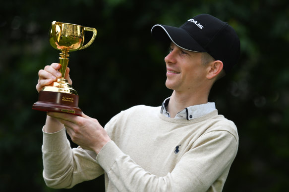 Jye McNeil poses with the Melbourne Cup at Treasury Gardens on Wednesday.