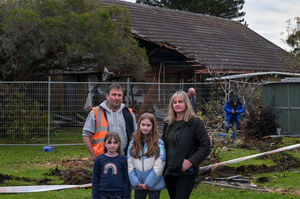 Tim Green in front of his parents’ damaged home with wife Danielle, daughters Bianca and Makaela.