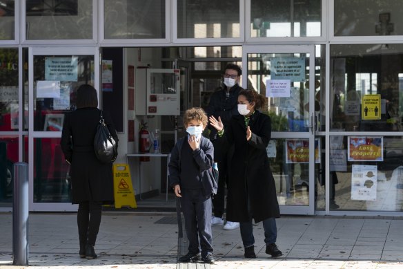 Isabel Batson collects her son from St Charles Primary School in Waverley after a child tested positive to COVID-19 on Tuesday. 