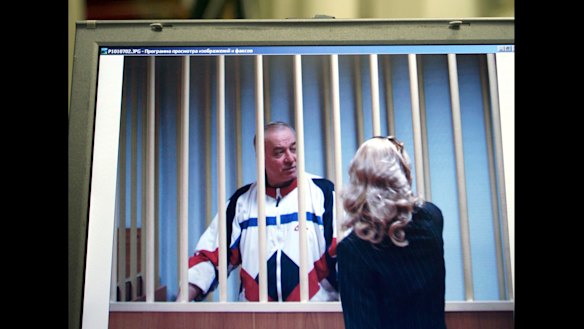 Sergei Skripal speaks to his lawyer from behind bars seen on a screen of a monitor outside a courtroom in Moscow in 2006.