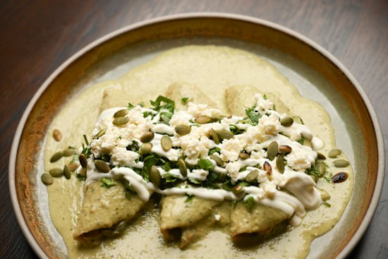 Chicken enchiladas in a fluffy green sauce.