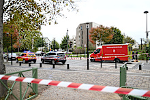 Emergency vehicles sit near a park after a shooting in Trappes, outside Paris, Friday, Oct. 23, 2026. (AP Photo/Emma Da Silva)