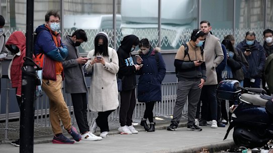 People line up to get a COVID-19 booster shot at University College London this month.