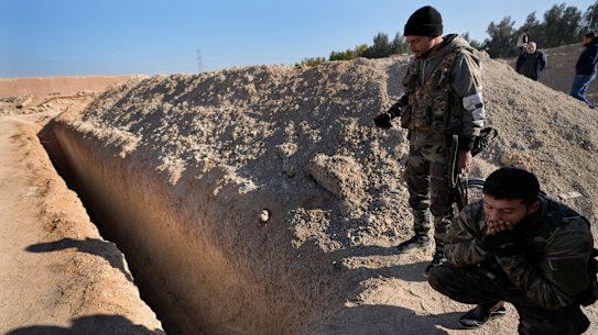 Syrian rebels observe a location identified as a mass grave for detainees killed under the rule of Bashar al-Assad in Najha, south of Damascus.