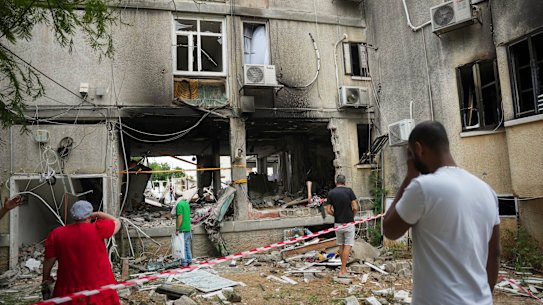 Israelis inspect a damaged residential building after it was hit by a rocket fired from the Gaza Strip, in Ashkelon, Israel, Monday, Oct. 9, 2023. 