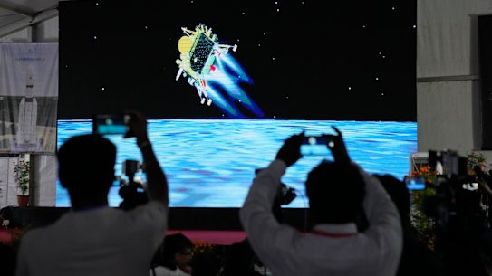 Journalists film a live feed of the moon-landing spacecraft Chandrayaan-3 at ISRO's Telemetry, Tracking and Command Network facility in Bengaluru, India.