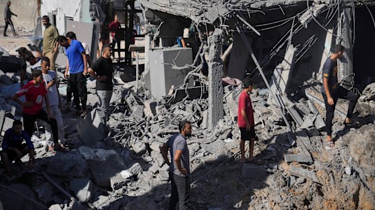 Palestinians look at buildings destroyed in the Israeli bombardment in the morgue in Deir al Balah, Gaza Strip on Tuesday.