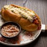 Completos (Chilean hot dogs) are tiger rolls cradling a simple frankfurt, diced tomato, avocado mash and mayonnaise.