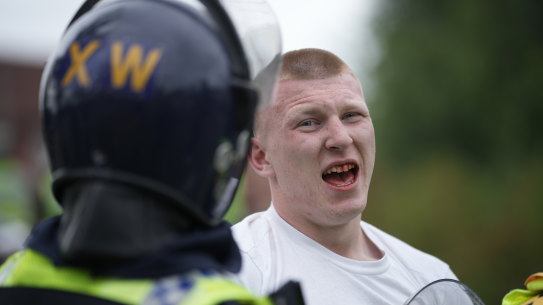 Riot police detain an anti-migration protester outside of the Holiday Inn Express in Manvers, which is being used as an asylum hotel in Rotherham, United Kingdom.