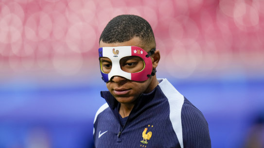 France’s Kylian Mbappe wears a face mask as he runs during a training session in Leipzig, Germany,