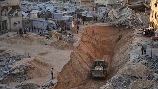 Palestinians watch members of Hamas searching for bodies of hostages in Khan Younis.