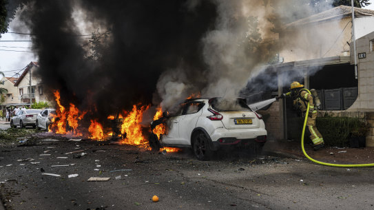Israeli firefighters extinguish fire at a site struck by a rocket fired from the Gaza Strip, in Ashkelon, southern Israel, on Monday.