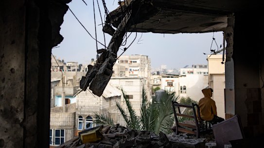 A Palestinian man sits in his house, which was destroyed in an Israeli strike, in Rafah, Gaza.