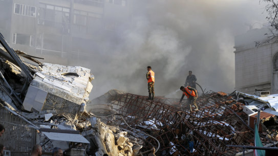 Emergency services work at the site of a destroyed building hit by an air strike in Damascus, Syria.