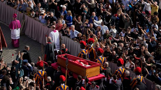 The ceremony with the Pope Francis’ body, who will lie in state at St. Peter’s Basilica for three days, pass through the crowd at the Vatican, Wednesday, April 23, 2025. (AP Photo/Gregorio Borgia)