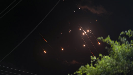 Missiles launched from Iran towards Israel streak across the night sky as seen from Deir al-Balah, Gaza Strip, Tuesday, Oct. 1, 2024. (AP Photo/Abdel Kareem Hana)