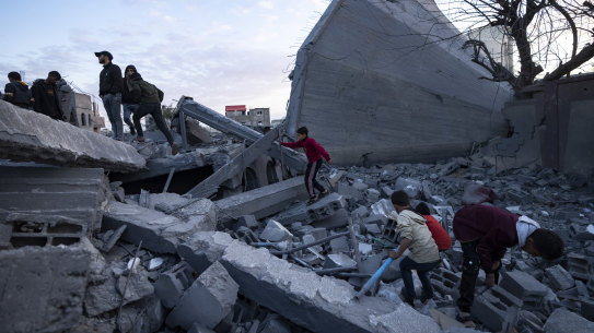 Palestinians look at a mosque destroyed in an Israeli strike in Rafah, Gaza Strip. 