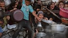 Palestinians struggle to get donated food at a community kitchen in Gaza City, northern Gaza Strip, Monday, July 14, 2025. (AP Photo/Jehad Alshrafi)