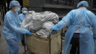 Hotel workers wearing personal protective equipments, carry rubbish from an isolation hotel in Hong Kong on Saturday.