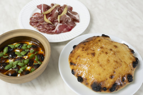 Clockwise from right: Wood-fired bread; stracciatella with charred heirloom tomatoes; affettati misti (cured meats).