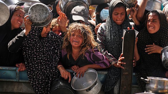 Palestinians struggle to get donated food at a community kitchen in Khan Younis, Gaza, late last week.