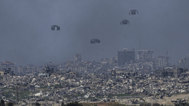 Gazans have many reasons to seek refuge. Parachutes drop supplies into the northern Gaza Strip, as seen from southern Israel on Wednesday. 