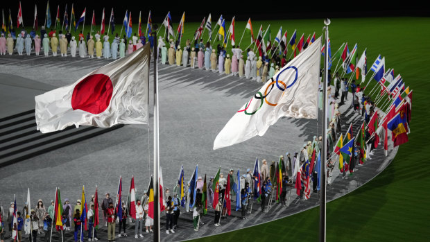 The Japan and Olympic flags fly as country flags are carried in during the closing ceremony.