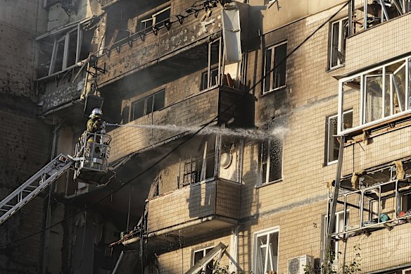 O pessoal de serviços de emergência trabalha para extinguir um incêndio após o maior ataque de drones russos desde o início da guerra.