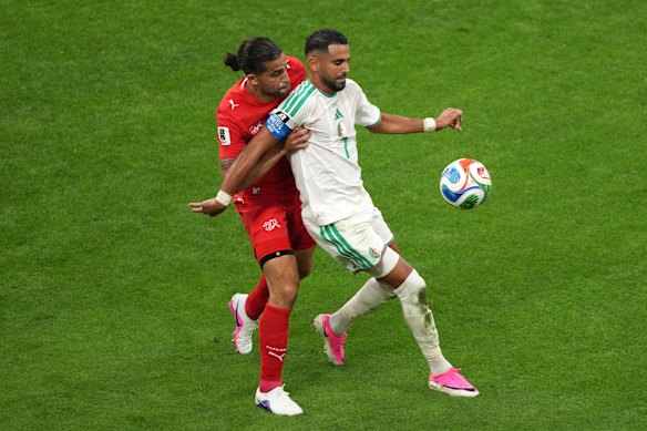 Switzerland’s Ricardo Rodriguez (13) battles with Algeria’s Riyad Mahrez (7).