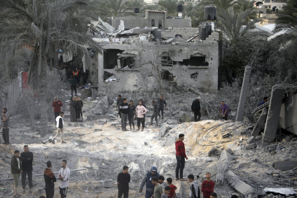 Palestinians inspect the damage of a destroyed house following Israeli airstrikes in the town of Khan Younis.