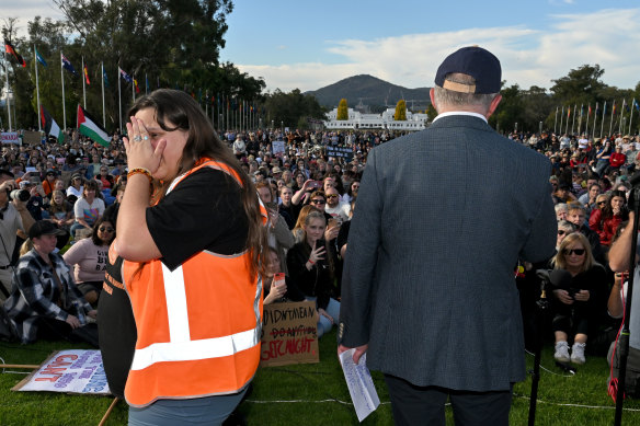Rally organiser Sarah Williams looks away as Prime Minister Anthony Albanese speaks at the event calling for an end to violence against women, in Canberra yesterday.