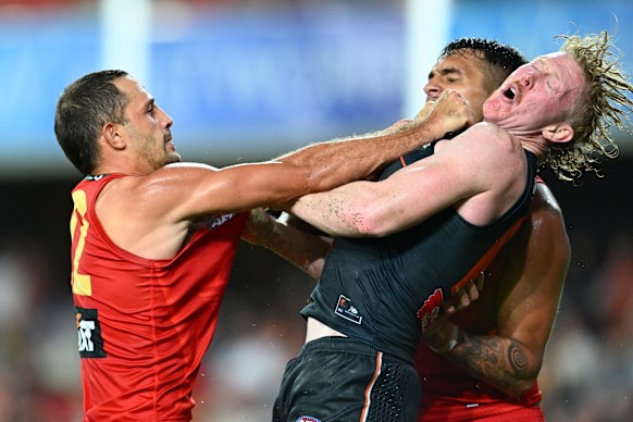 Push and shove: GWS Giant Clayton Oliver comes up short in this clash.