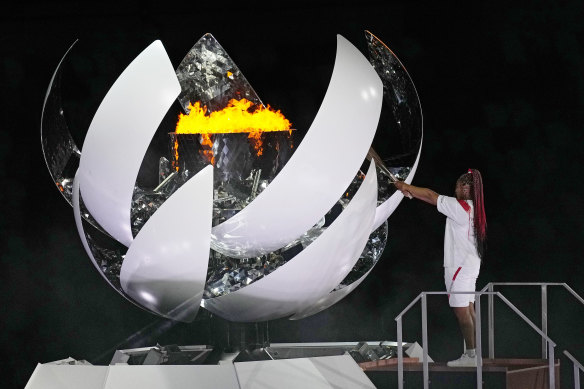 Naomi Osaka lights the Olympic flame during the opening ceremony in Tokyo.
