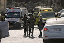 Israeli soldiers and emergency personnel gather near ambulances at a junction near Hebron in the occupied West Bank.