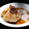 Roti banjir - roti bread in curry sauce with two soft-boiled eggs and sambal.