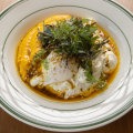 Vadouvan eggs: Poached eggs drizzled with spiced ghee and garnished with zaatar over herbed carrot puree and lemon labne.