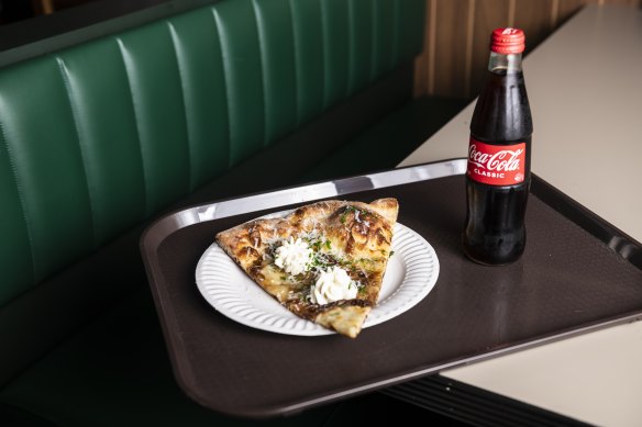 A slice of White pizza (garlic oil, house-cheese mix, ricotta and caramelised onions on a sesame-crust base).