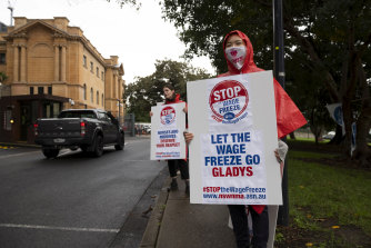 Nurses are holding placards outside Parliament.