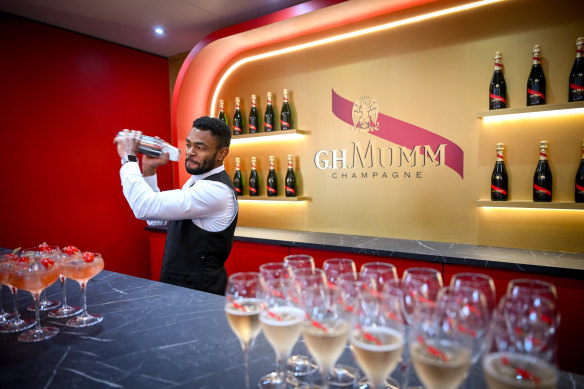 A bartender serves champagne in the ‘Théâtre G.H. Mumm’ marquee.